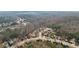 Wide aerial shot of a neighborhood, showcasing the layout and surrounding wooded areas at 3308 Hunting Creek Pass, Douglasville, GA 30135