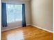Bedroom with hardwood flooring and natural light from a window with dark curtains at 3308 Hunting Creek Pass, Douglasville, GA 30135