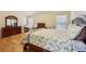 Bright bedroom features a paisley bedspread, hardwood floors, and natural light at 3308 Hunting Creek Pass, Douglasville, GA 30135