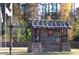 Community entrance featuring sign and wood structure with stone base at 3308 Hunting Creek Pass, Douglasville, GA 30135