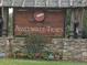 Charming community entrance sign featuring a stone base and decorative timber accents at 3308 Hunting Creek Pass, Douglasville, GA 30135