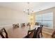 Comfortable dining area featuring a table set for eight, a chandelier, and a window providing natural light to the room at 3308 Hunting Creek Pass, Douglasville, GA 30135