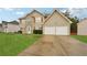 Traditional two-story house featuring a two-car garage, symmetrical design, and inviting curb appeal in a suburban setting at 3308 Hunting Creek Pass, Douglasville, GA 30135