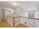 Bright hallway featuring hardwood floors, wood and white banister, and a window over the front door at 3308 Hunting Creek Pass, Douglasville, GA 30135