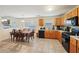 Eat-in kitchen featuring wood cabinets, black appliances, tile flooring and view to the dining area at 3308 Hunting Creek Pass, Douglasville, GA 30135