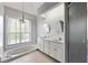 Bathroom featuring a jacuzzi tub, dual sinks, natural light from a large window, and tile floors at 5445 Mountain Trl, Douglasville, GA 30135