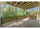 Covered wooden deck with decorative latticework overlooking a lush, green landscape and tree-filled backyard at 5445 Mountain Trl, Douglasville, GA 30135