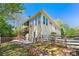 Exterior view of home with a deck and patio area, fenced yard, complemented by lush greenery and blue skies at 5445 Mountain Trl, Douglasville, GA 30135