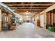 Unfinished basement with exposed wood beams, concrete floor, shelving, and walkout door at 140 Discovery Lake Dr, Fayetteville, GA 30215