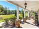 Spacious covered porch featuring stone columns, hanging lights, and views of the landscaped front yard and neighborhood at 140 Discovery Lake Dr, Fayetteville, GA 30215