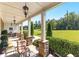 Inviting covered porch with stone pillars, outdoor seating, and a view of the expansive green lawn at 140 Discovery Lake Dr, Fayetteville, GA 30215
