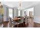 A well-lit dining room features a large wooden table, upholstered chairs, chandelier and hardwood floors at 140 Discovery Lake Dr, Fayetteville, GA 30215