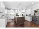 A spacious kitchen features modern white cabinets, dark island, stainless appliances, and beautiful dark hardwood floors at 140 Discovery Lake Dr, Fayetteville, GA 30215