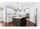 Bright kitchen with white cabinetry, stainless steel appliances, an island with granite countertops and wood floors at 140 Discovery Lake Dr, Fayetteville, GA 30215