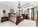 Beautiful bedroom features a tray ceiling, chandelier, fireplace, and luxurious finishes at 140 Discovery Lake Dr, Fayetteville, GA 30215