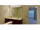 Bathroom featuring a double sink vanity, large mirror, and a view into the bedroom at 2004 Burns View Ln, Lawrenceville, GA 30044