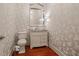 Elegant half bathroom featuring a mirrored vanity, brushed nickel fixtures, and floral wallpaper at 2805 Cambria Ct, Cumming, GA 30041