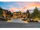 Elegant home exterior with beautiful landscaping, circular driveway, and stone accents at dusk at 2805 Cambria Ct, Cumming, GA 30041