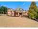Stately brick and stone home with a manicured lawn and mature trees at 2805 Cambria Ct, Cumming, GA 30041