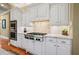 Gourmet kitchen featuring a stainless steel range, double oven, and backsplash with granite countertops and white cabinets at 2805 Cambria Ct, Cumming, GA 30041