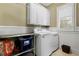Well-organized laundry room with cabinetry, washer, dryer, and natural light at 2805 Cambria Ct, Cumming, GA 30041