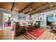 Inviting living area features wood beam ceilings, comfortable seating, with views to other entertaining spaces at 2805 Cambria Ct, Cumming, GA 30041