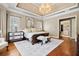 Charming primary bedroom features a tray ceiling, hardwood floors, and elegant decor at 2805 Cambria Ct, Cumming, GA 30041