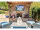 Inviting outdoor living space with a stone fireplace, television, and comfortable seating at 2805 Cambria Ct, Cumming, GA 30041