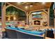Inviting outdoor living space with a stone fireplace, television, and comfortable seating by the pool at 2805 Cambria Ct, Cumming, GA 30041