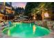 Beautiful pool with a stone waterfall, palm trees, and a fire feature, creating a serene outdoor oasis at 2805 Cambria Ct, Cumming, GA 30041