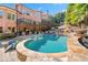 Expansive backyard with a pool, waterfall, covered patio, and lush landscaping at 2805 Cambria Ct, Cumming, GA 30041