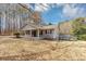 Side view of a single-story home featuring gray siding, a deck, and a spacious, unfenced yard at 4251 Klondike Rd, Lithonia, GA 30038