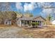 Single-story home featuring a covered front porch, gray siding, an outbuilding, and a spacious yard at 4251 Klondike Rd, Lithonia, GA 30038