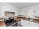 Close-up of the kitchen featuring white cabinets, stainless steel appliances, and laminate countertops at 4251 Klondike Rd, Lithonia, GA 30038