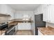 Bright kitchen featuring white cabinets, stainless steel appliances, and wood-look flooring at 4251 Klondike Rd, Lithonia, GA 30038