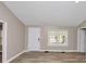 Light-filled living room with wood-look flooring, neutral paint, and a view of the front yard through the window at 4251 Klondike Rd, Lithonia, GA 30038