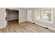 Spacious living room with wood-look flooring, neutral walls, and ample natural light, leading to other rooms at 4251 Klondike Rd, Lithonia, GA 30038