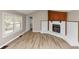 Cozy living room featuring wood-look floors, a brick fireplace, and plenty of natural light from the window at 4251 Klondike Rd, Lithonia, GA 30038