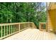 Wooden back deck and railing overlooking a green, lush yard with mature trees at 7281 Fernwood Dr, Riverdale, GA 30296