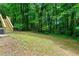 Expansive green backyard featuring steps leading to a deck area, perfect for outdoor activities at 7281 Fernwood Dr, Riverdale, GA 30296
