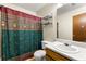 Cozy bathroom featuring a vanity, toilet, shelving and a shower with green patterned curtain at 7281 Fernwood Dr, Riverdale, GA 30296