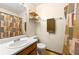 Modest bathroom featuring a single sink, light wood vanity, and patterned shower curtain at 7281 Fernwood Dr, Riverdale, GA 30296