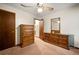 Carpeted bedroom features a ceiling fan, an entry door and dark wood furniture at 7281 Fernwood Dr, Riverdale, GA 30296
