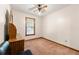 An empty carpeted bedroom features a ceiling fan, window, and dark wood furniture at 7281 Fernwood Dr, Riverdale, GA 30296