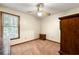 Bedroom features a window, ceiling fan, carpeted floor, and dark wood furniture at 7281 Fernwood Dr, Riverdale, GA 30296