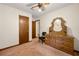 Carpeted bedroom with a ceiling fan, entry door and dark wood furniture at 7281 Fernwood Dr, Riverdale, GA 30296