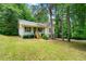 Quaint one-story house with inviting front porch and lush greenery at 7281 Fernwood Dr, Riverdale, GA 30296