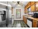 Classic kitchen features wood cabinets, stainless steel refrigerator, and black and white patterned flooring at 7281 Fernwood Dr, Riverdale, GA 30296