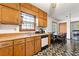 Kitchen features wood cabinets, stainless steel sink, dishwasher, and a dining area with a wooden table at 7281 Fernwood Dr, Riverdale, GA 30296