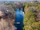 Aerial view of a peaceful pond surrounded by lush trees, with a dock visible along the water's edge at H-5422 Hill Sw Rd, Powder Springs, GA 30127